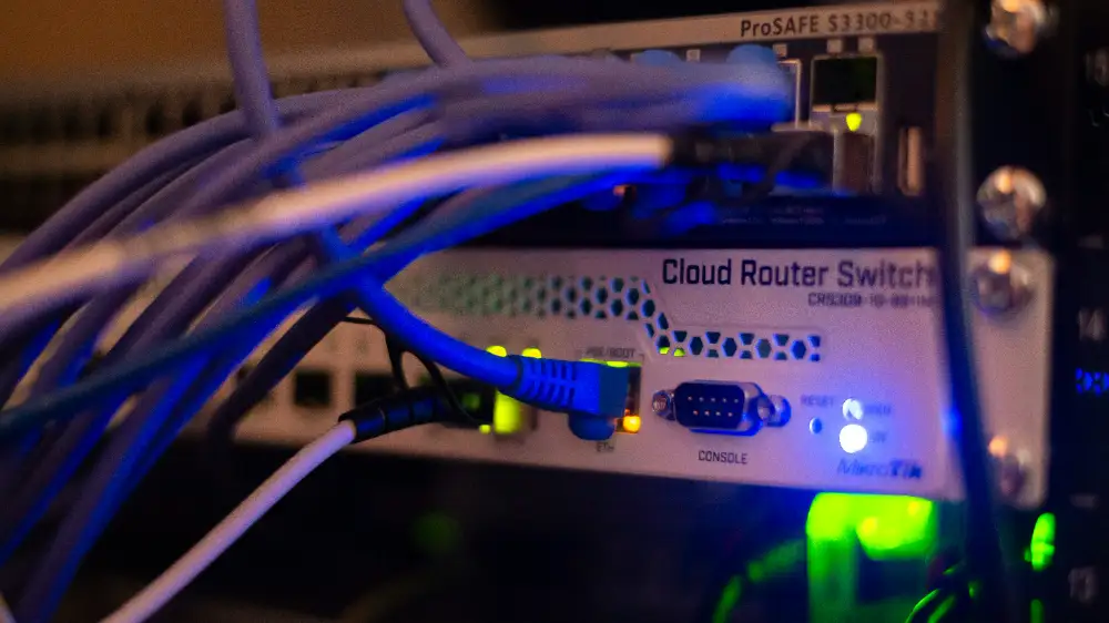 Close-up of a Cloud Router Switch with network cables connected, highlighting the device's LED indicators and ports, illustrating a modern networking setup.